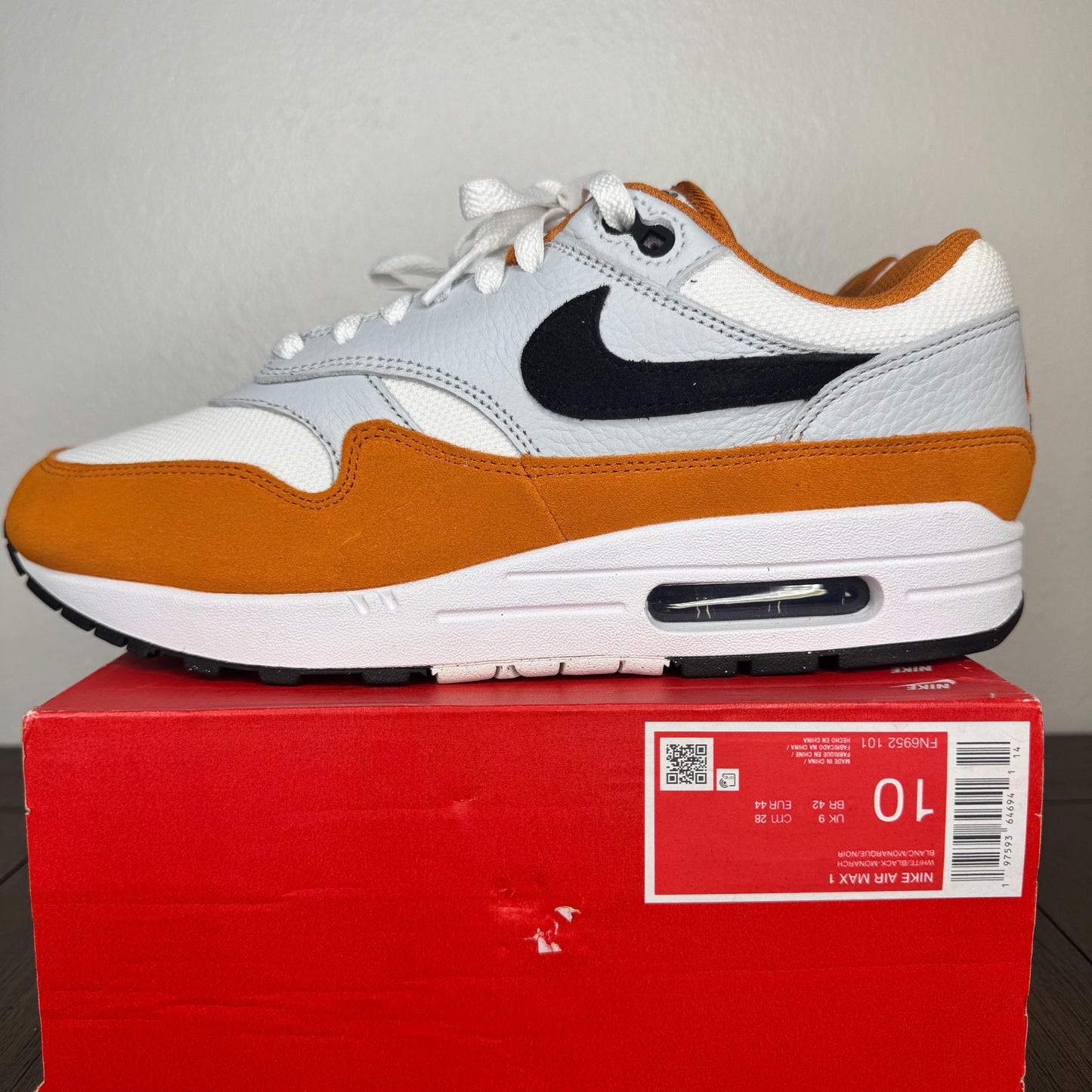 White and brown sneaker on a red box with a gray background