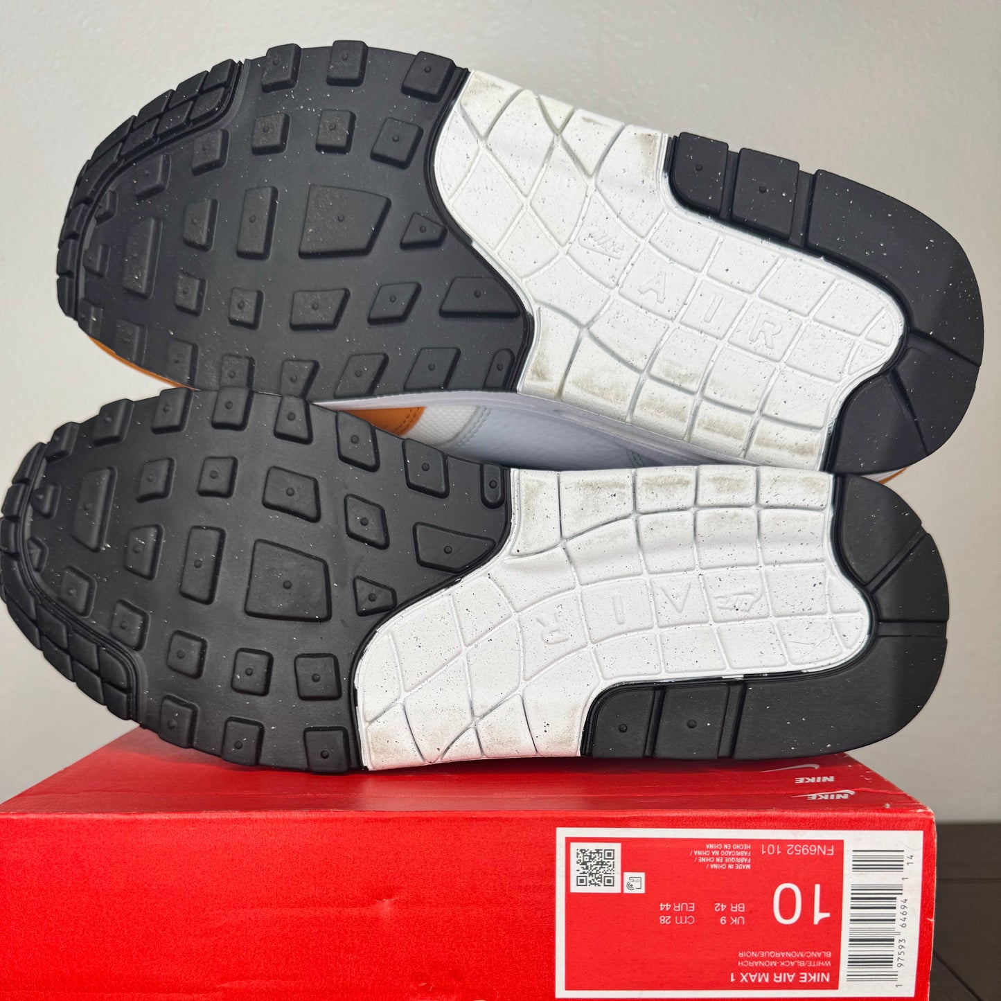 Black and white sneakers on a red box with a visible brand label.